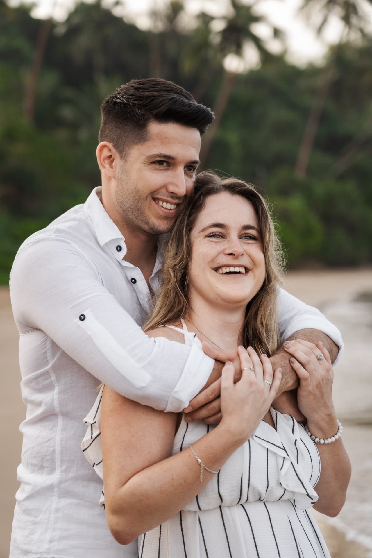 Nadja und Markus umarmen sich lachend am Meer
